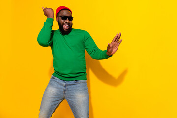 Wall Mural - Photo of funky cheerful man enjoy dance have fun wear sunglass red beanie green shirt isolated yellow color background