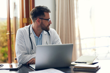 Poster - Theres a lot of unseen work that doctors do. Cropped shot of a handsome male doctor working on his laptop while sitting in his office.