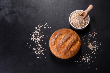 Tasty fresh baked in oven white bread on a dark concrete background