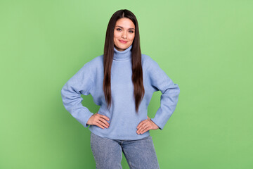 Canvas Print - Photo of confident shiny mature lady dressed blue pullover hands waist walking smiling isolated green color background