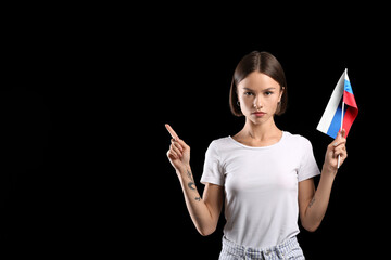 Sticker - Beautiful young woman with flag of Russia pointing at something on dark background