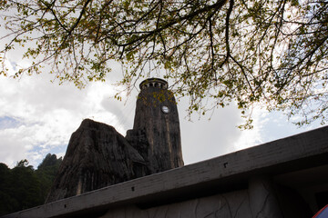 An interesting photo of a unique church made of stone, brutal style, against the background of the sky and branches, el Peñol Colombia