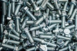 Metal screw bolts top view as industrial equipment background.