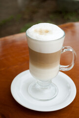 Poster - Glass cup served with Capuccino coffee, aromatic coffee from Guatemala served outdoors