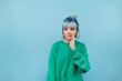 © bodnarphoto - Cute shy hipster girl with colored hair speaks in secret and looks away on a blue background.