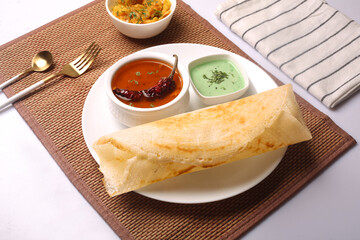 Poster - Closeup of a Masala dosa Indian dish, Thick green pea soup dish and a Rasam spicy soup on a table