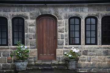 Canvas Print - Close-up shot of a building facade view with a wooden door and windows