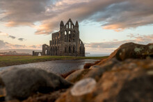 Selective Focus Shot Of Whitby Abbey Under A Beautiful Cloudy Sky, Colored By The Sunbeams