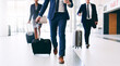 Our business requires us to travel. Cropped shot of three unrecognizable businesspeople walking and pulling suitcases while in the office during the day.