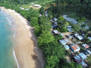 Wall Mural - Beautiful view of the sandy beach with green vegetation and houses. Ilha do Principe.