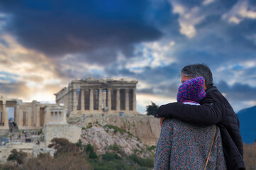 couple in love looks embracing the Acropolis of Athens, Greece