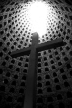 Vertical Shot Of An Underground Cross In The Crypt Of Sighs Surrounded With The Holes In Grayscale