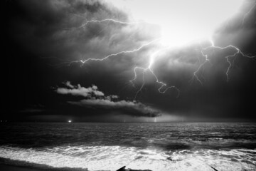 Wall Mural - Grayscale shot of dramatic cloudy sky with thunderstorm and lightning