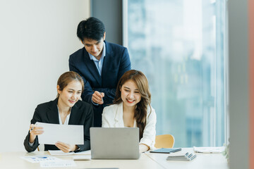 group of four happy young asian corporate people teammates meeting discussing business in office.