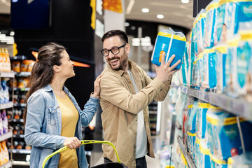 A happy parents buying diapers at supermarket.