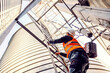 © Dusan Petkovic - A worker climbing up the metal construction on the silo.