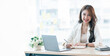 © NAMPIX - Young asian beautiful and charming businesswoman smiling and working on laptop computer at office.