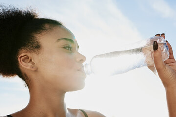 Wall Mural - Taking an H2O timeout. Closeup shot of a sporty young woman drinking water after her workout.