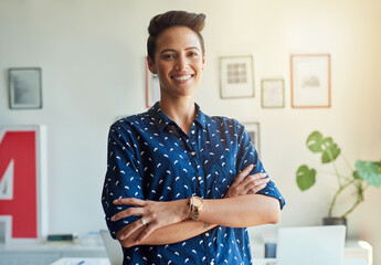 Wall Mural - Im confident in my creations. Cropped portrait of an attractive young female designer standing with her arms folded in the office.