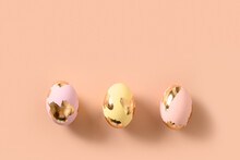 Three Colorful Eggs Decorated Gold Foil On Pink Background. Happy Easter Greeting Card With Copy Space. Top View.