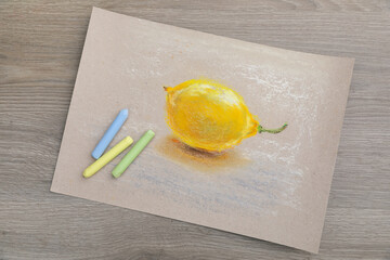 Canvas Print - Beautiful drawing of lemon and pastels on wooden table, top view