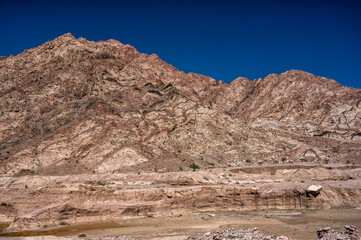 Wall Mural - Mountains between the city of Aqaba and the Wadi Rum Protected Area near the Jordan-Saudi border. Tutun, Jordan.