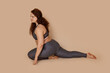 © Юля Бурмистрова - Attractive groomed fat obese plump woman doing sports stretch, sitting half splits. Exercises for spine and muscles. Burning fast calories, self acceptance concept. Wearing gray sportswear. Side view