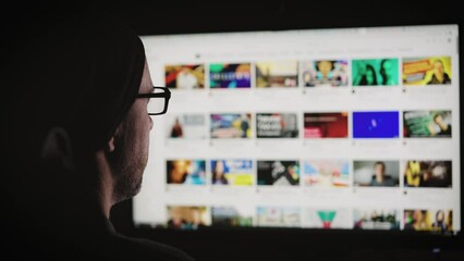 A man chooses a video to watch. The largest video hosting, contains a huge amount of video content.