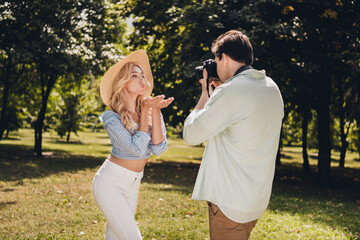 Poster - Portrait of two attractive cheerful couple guy taking captures of model posing pastime sending air kiss outdoors