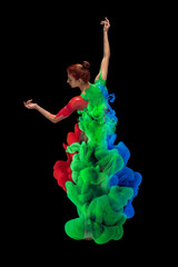 Wall Mural - Portrait of young tender woman covered with red, blue and green paint and dye splah dancing isolated over black background