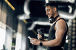 © Prostock-studio - Fitness App. Smiling Arab Sporty Man Using Smartphone While Standing In Gym