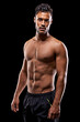 © Duncan M/peopleimages.com - Get big or die trying. Studio portrait of a handsome bare-chested young athlete standing against a black background.