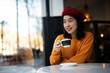 © Jelena - Beautiful Chinese woman drinking coffee in cafe. Young smiling woman enjoy in restaurant