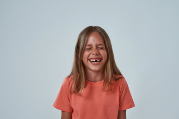 Wall Mural - Portrait of laughing little girl with closed eyes