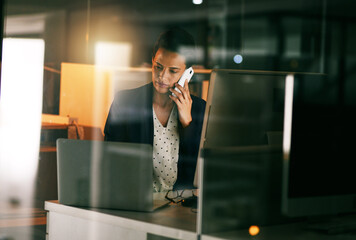 Poster - The job will get done, no matter what. Shot of a young businesswoman working late in an office.
