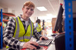 © Monkey Business - Portrait Of Male Intern Working In Busy Modern Warehouse On Computer Terminal