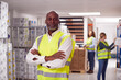© Monkey Business - Portrait Of Team Male Leader In Warehouse With Staff Picking Items From Shelves In Background