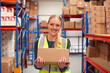 © Monkey Business - Portrait Of Female Worker Holding Box Inside Warehouse