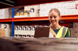 © Monkey Business - Female Worker Picking Box From Shelf Inside Warehouse