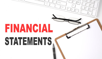 Poster - FINANCIAL STATEMENTS text written on white background with keyboard, paper sheet and pen