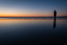 Silhouette Of A Person At Sunset On Shishi Beach In Washington