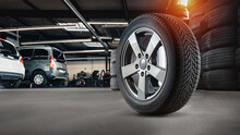 Tire At Repairing Service Garage Background. Technician Man Replacing Winter And Summer Tyre For Safety Road Trip. Transportation And Automotive Maintenance Concept