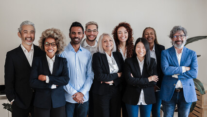 multi-ethnic generational modern office: successful business team smiling on camera - focus on asian