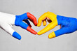 hands of russian and ukrainian flags colors, symbol of truce and consent between Russia and Ukraine, stop war in Ukraine