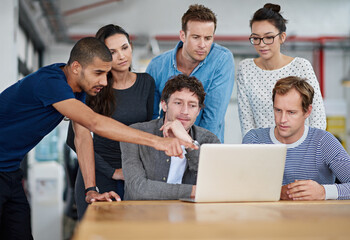 Poster - Hes got the winning idea. Shot of a group of colleagues using a laptop together in a casual work environment.