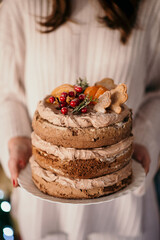 Canvas Print - Vertical shot of a female holding a delicious creamy cake