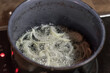 Geschnittene Zwiebel Zwiebelringe in einem Topf mit heißem Fett werden Röstzwiebel gemacht gebacken, Deutschland