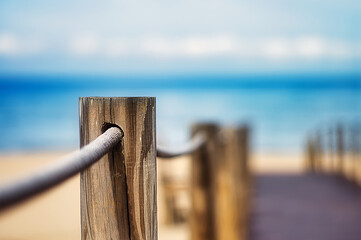 Wall Mural - Selective focus shot of Wooden poles with a rope on the edge of a walkway