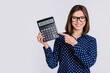 © deagreez - Portrait of attractive cheerful girl demonstrating number calculator cash savings isolated over grey pastel color background