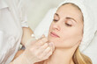 © elenavolf - Injection at spa salon. Doctor hands in gloves. Closeup. Pretty female patient. Beauty treatment. Healthy skin procedure. Young women face. Plasmolifting rejuvenation